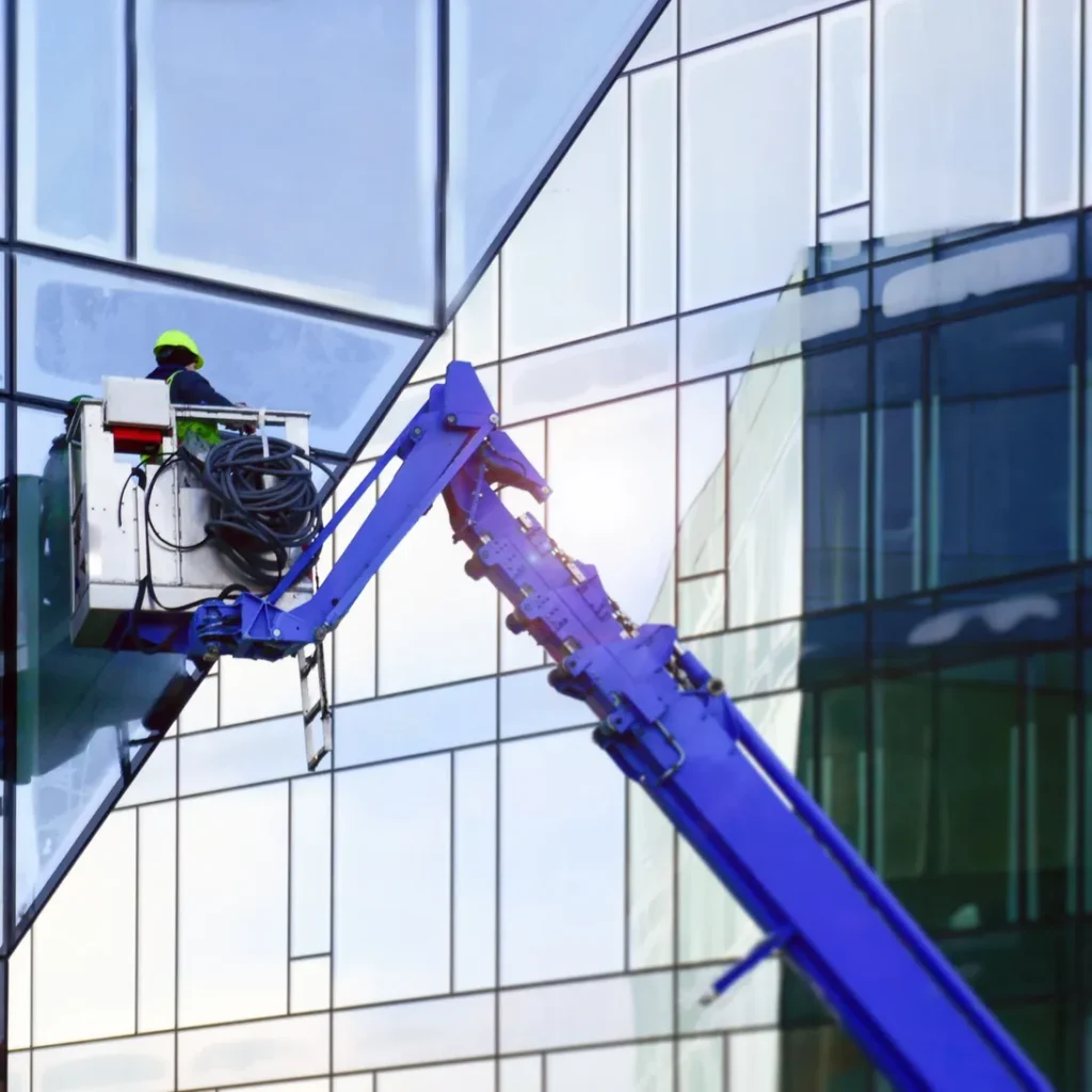 Technicien de Calfeutrage Scelléo en nacelle faisant le calfeutrage des joints de façade d’un immeuble commercial à Montréal